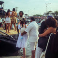 Jovens aproveitando um cruzeiro com DJ e drinks ao pôr do sol frente aos prédios de Bocagrande.