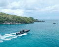 Speedboat on a clear blue sea with a rocky island in the Rosario Islands