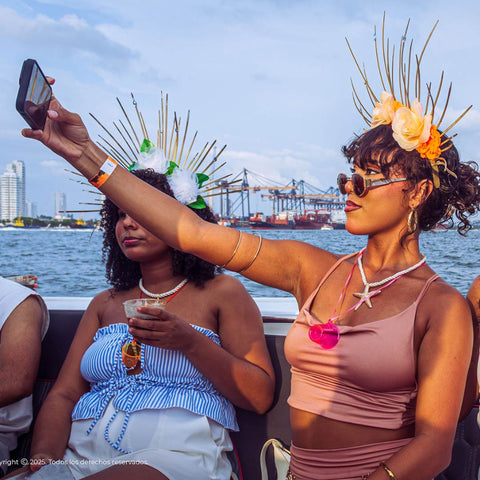 Two women taking a selfie on a boat with a Cartagena skyline in the background